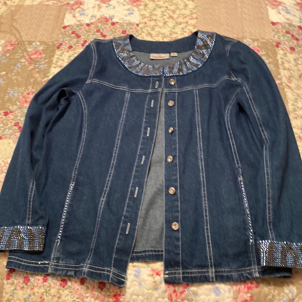 Denim with neck and cuffs studded with stones and large diamond like buttons